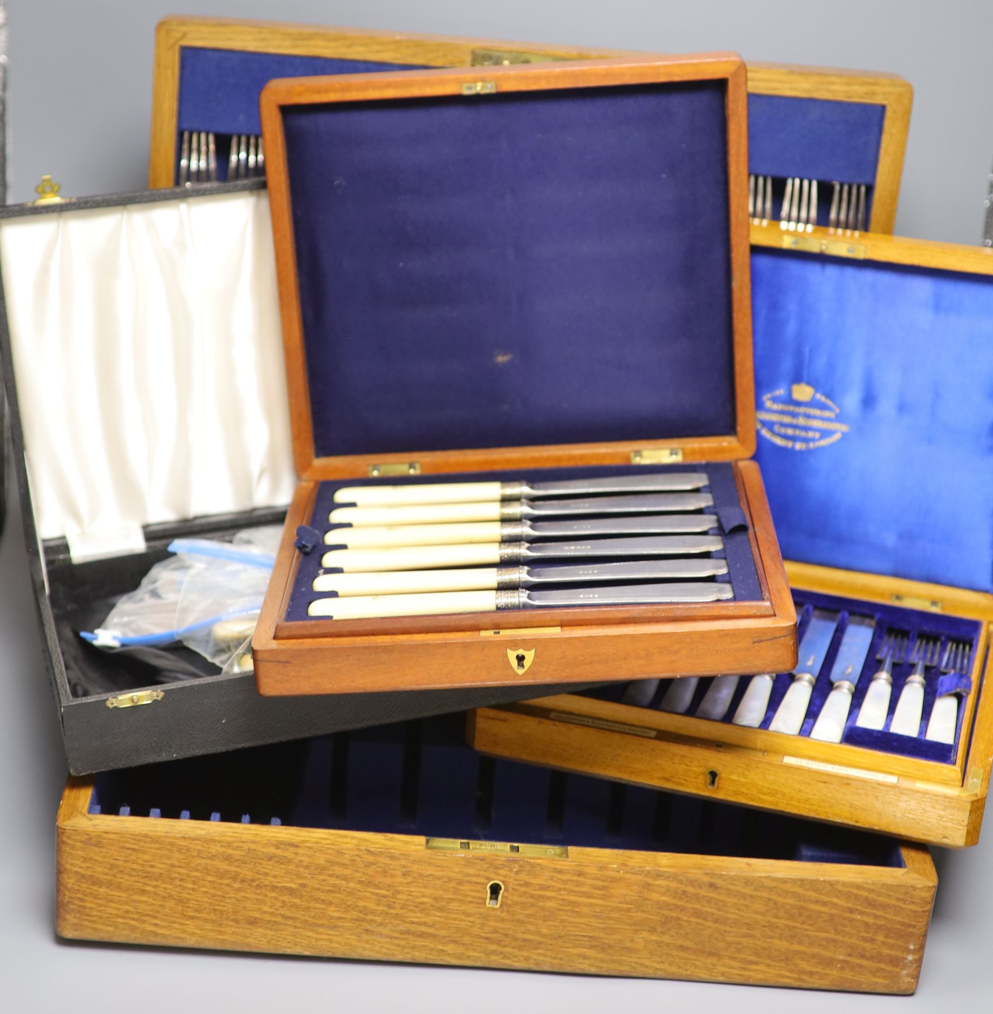 A cased set of silver dessert knives and forks and two other boxes